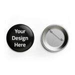 Mockup of a round button pin showing front with 'Your Design Here' text in white on black background and back with metallic pin clasp, demonstrating customizable badge printing.