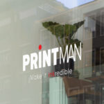 Shopfront window sticker mockup featuring the Printman logo with 'Make it inkredible' tagline on a glass window, ideal for custom branded decals.