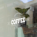 Shopfront window sticker mockup featuring a vintage-style coffee shop design with the words 'Handmade Quality Coffee, Sweet & Tasty, Best coffee in Amman', ideal for custom window decal printing.